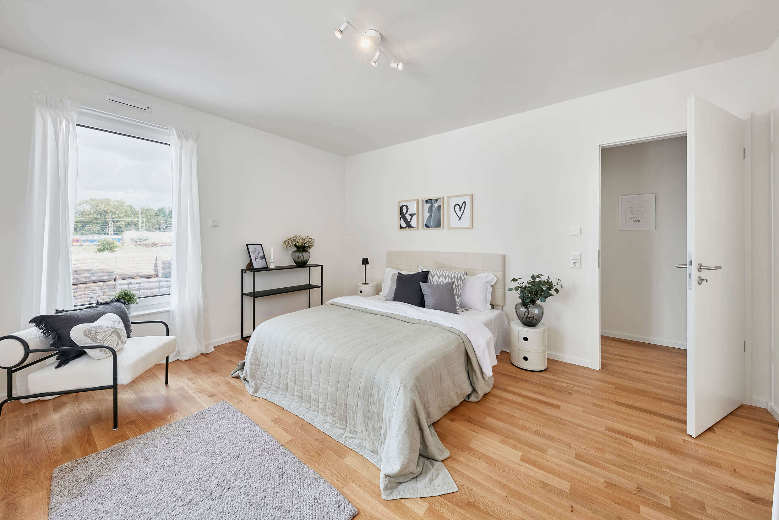 Schlafzimmer der Musterwohnung zur Miete in der Neuen Meile, Parkettboden, Blick auf das Doppelbett und die göffnete Zimmertür