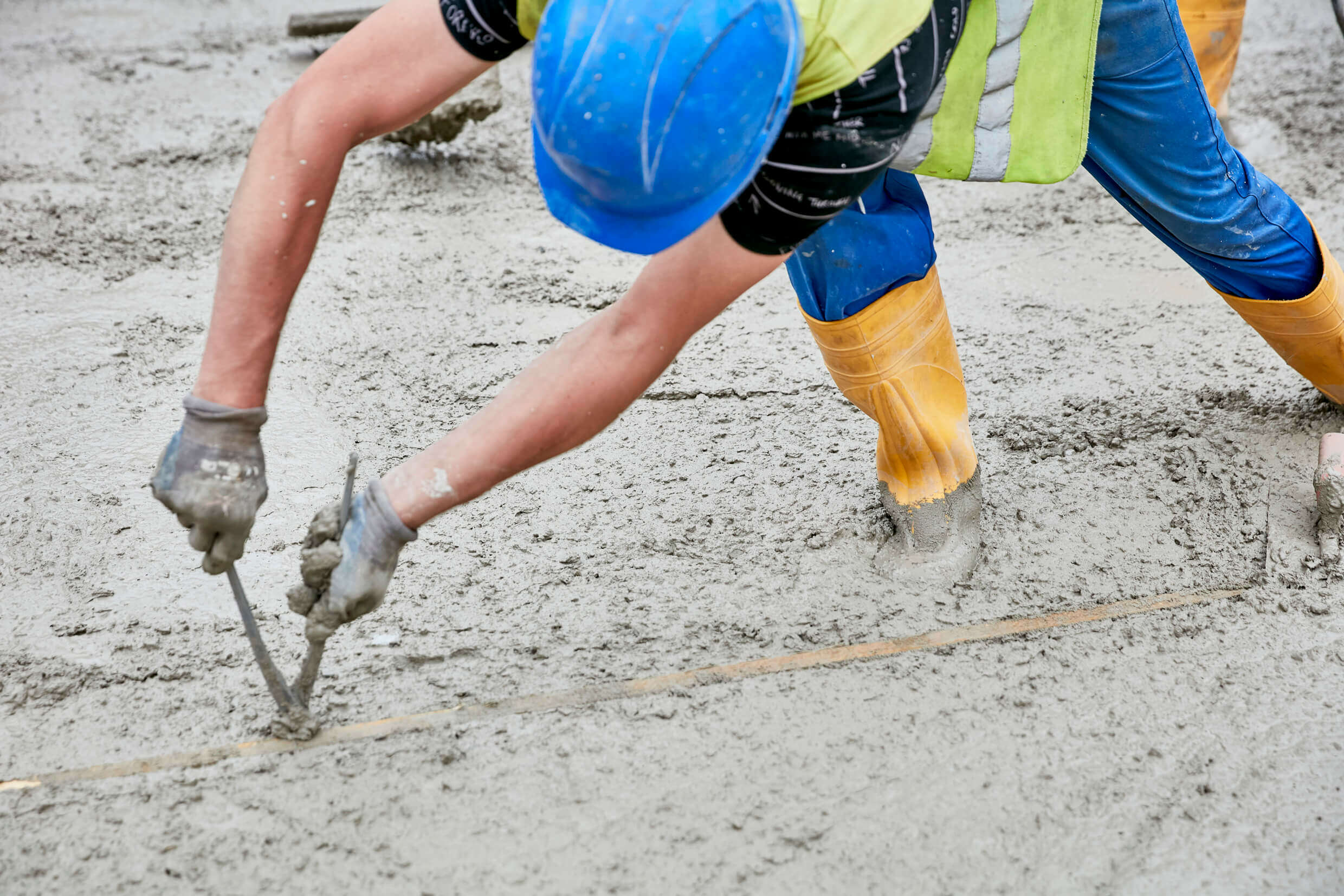 Neue Meile – der frische Beton wird durch eine Bauarbeiter geprüft